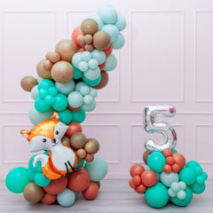 A balloon garland featuring a fox shape and a number '5' made from balloons in various colors.