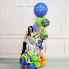 A bouquet of balloons with a science-themed balloon, personalized messages, and a variety of bright colors, including blue, green, orange, and multicolored balloons.