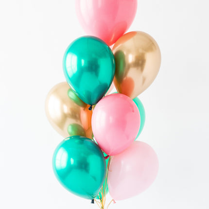 Bouquet of colorful balloons including pink, green, and gold on a white background