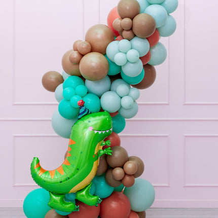 A colorful balloon garland featuring a dinosaur-themed balloon prominently placed amidst a variety of other shapes and colors.