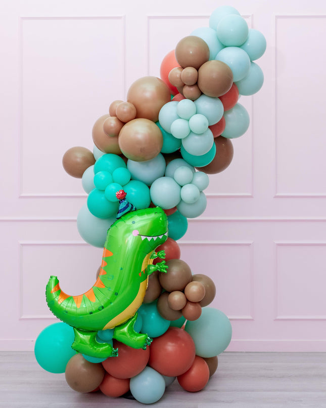 A colorful balloon garland featuring a dinosaur-themed balloon prominently placed amidst a variety of other shapes and colors.