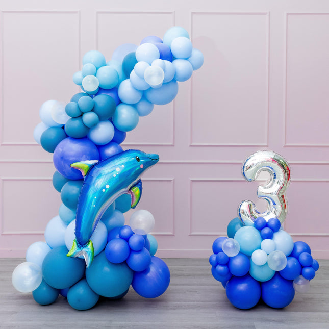 A balloon garland featuring a dolphin shape with a number 3, predominantly in shades of blue.