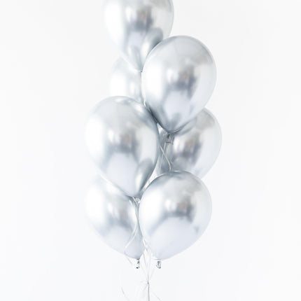 A bunch of silver-colored balloons tied together against a white background.