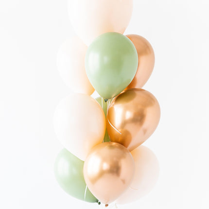 A bunch of round balloons in shades of pink, green, and gold, tied together with a string.