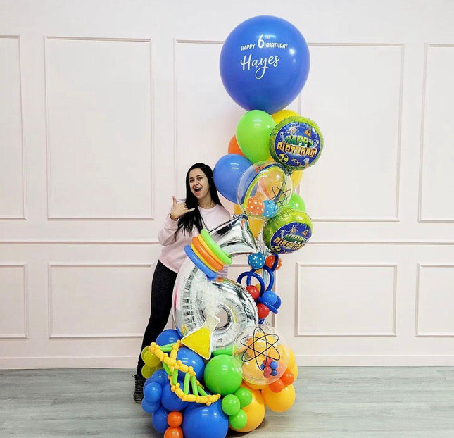 A bouquet of balloons with a science-themed balloon, personalized messages, and a variety of bright colors, including blue, green, orange, and multicolored balloons.